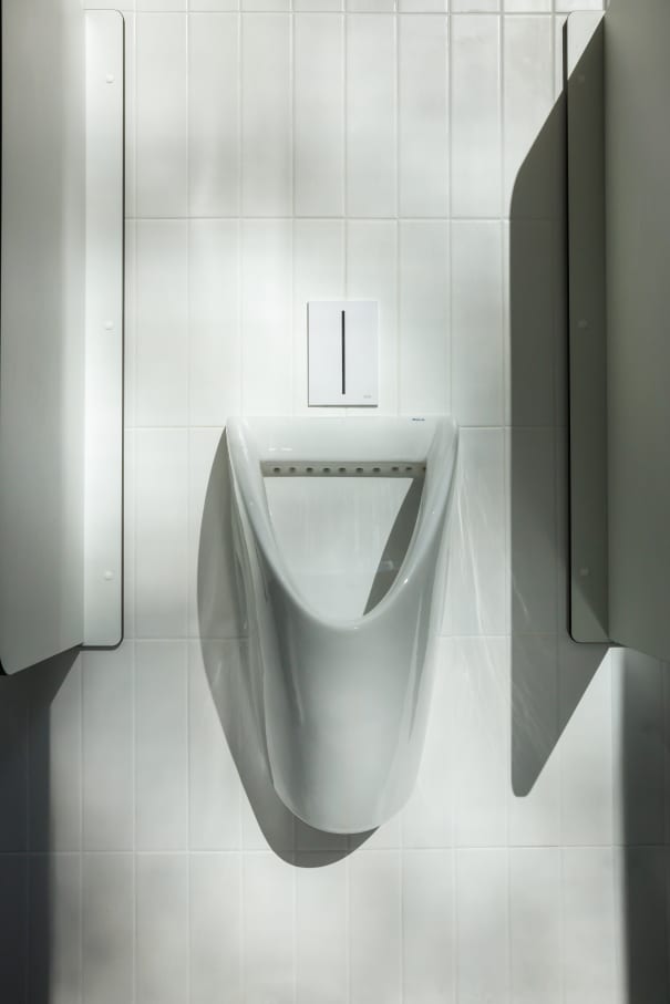 The interior design of TriQube's bathrooms embraces a serene, minimalist aesthetic, with rounded shapes and a soothing colour palette creating a calming atmosphere. Chic urinals add a touch of distinction, offering both urban flair and unique appeal, while Access grab bars and Meridian toilets ensure accessibility and comfort. Roca products were carefully selected to enhance both the functionality and innovative spirit of the space, contributing to its high standards of quality and design.10
